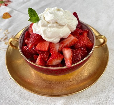 Bowl of strawberries topped with whipped cream